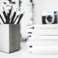 求职内容编辑陈立坐在办公桌前审阅简历模板排版细节，屏幕上显示着带批注的简历文档，环境明亮整洁